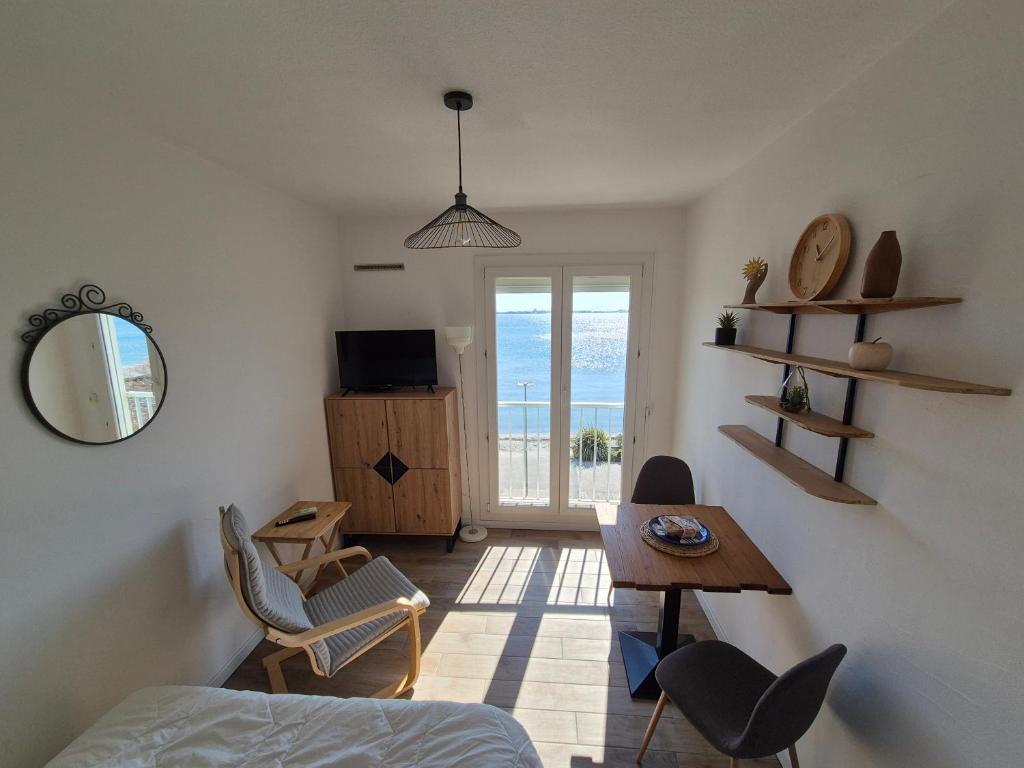 une chambre avec un lit, une table et des chaises dans l'établissement Studio 19m2 classé 1, vue sur étang de Thau, 200m des cures, 2eme Étage sans ascenseur, à Balaruc-les-Bains