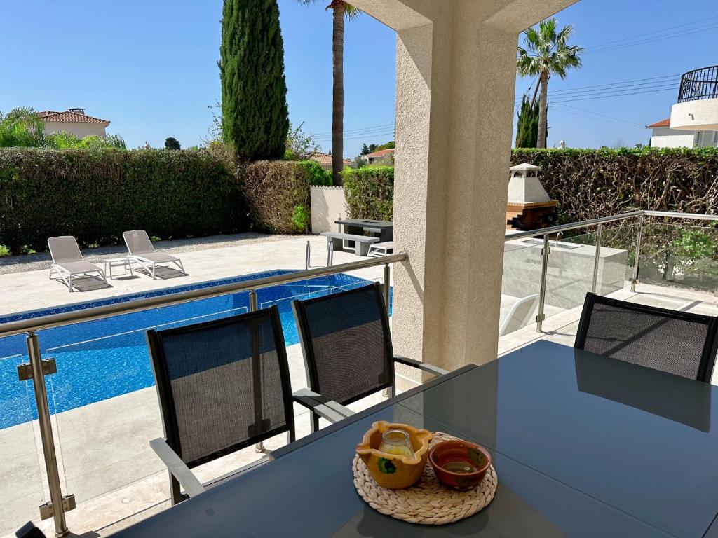 a glass table with a bowl of food on it next to a pool at Villa M & S in Coral Bay