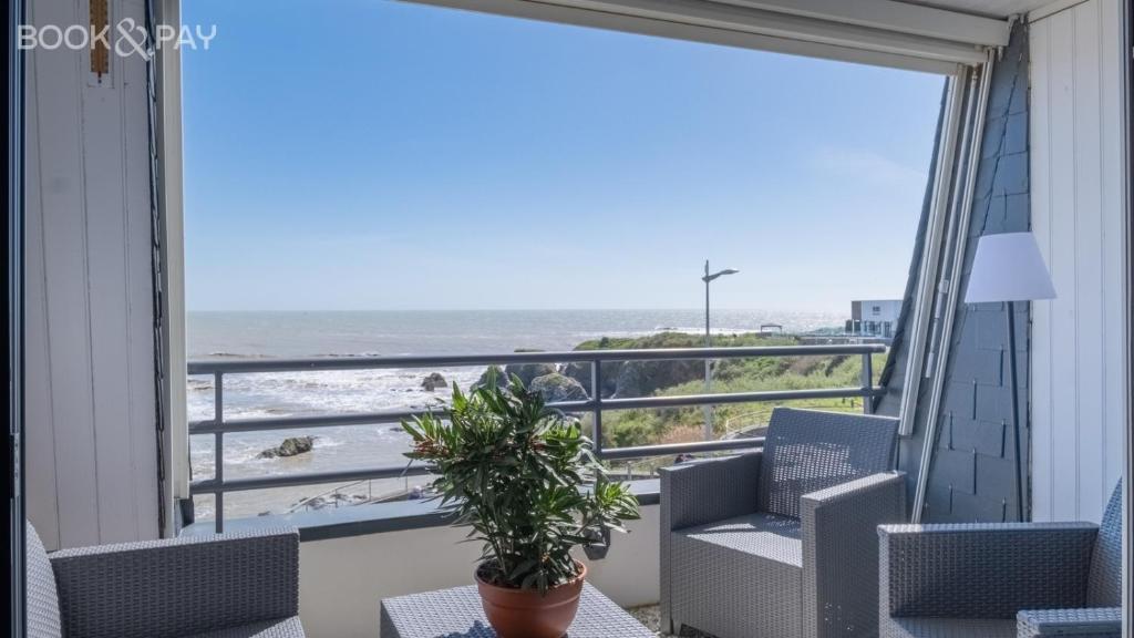 d'un balcon avec des chaises et une vue sur l'océan. dans l'établissement appartement vue mer sur la corniche ST Hilaire de riez résidence Sémaphore, à Saint-Hilaire-de-Riez