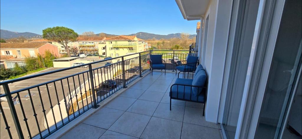 un balcon avec des chaises et une vue sur la ville dans l'établissement Nice apartment for 2 with balcony, à Cogolin