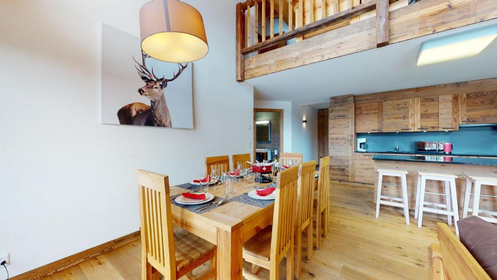 a dining room and kitchen with a wooden table and chairs at Les Mayens MA 021 - LUXURY apartment 18 pers in Veysonnaz
