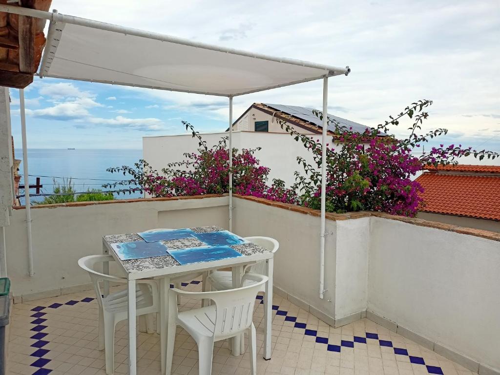 a table and chairs on a balcony with a view of the ocean at Bougainvillea in San Vito Chietino