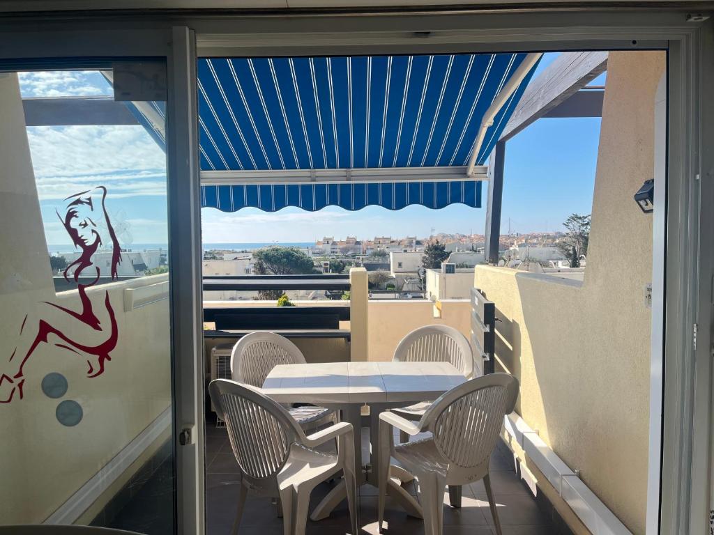 une table et des chaises sur un balcon avec vue dans l'établissement CapNat - Village Naturiste - Port Nature - Le Bisou, au Cap d'Agde