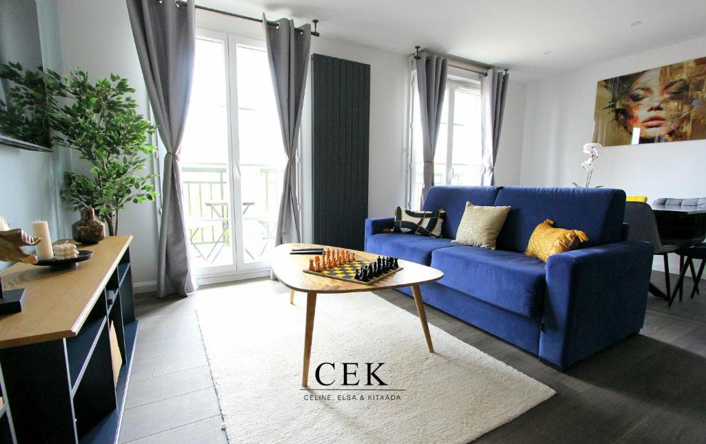 un salon avec un canapé bleu et une table dans l'établissement Garonne8 - Spacious accomodation 8ppl Disneyland, à Serris