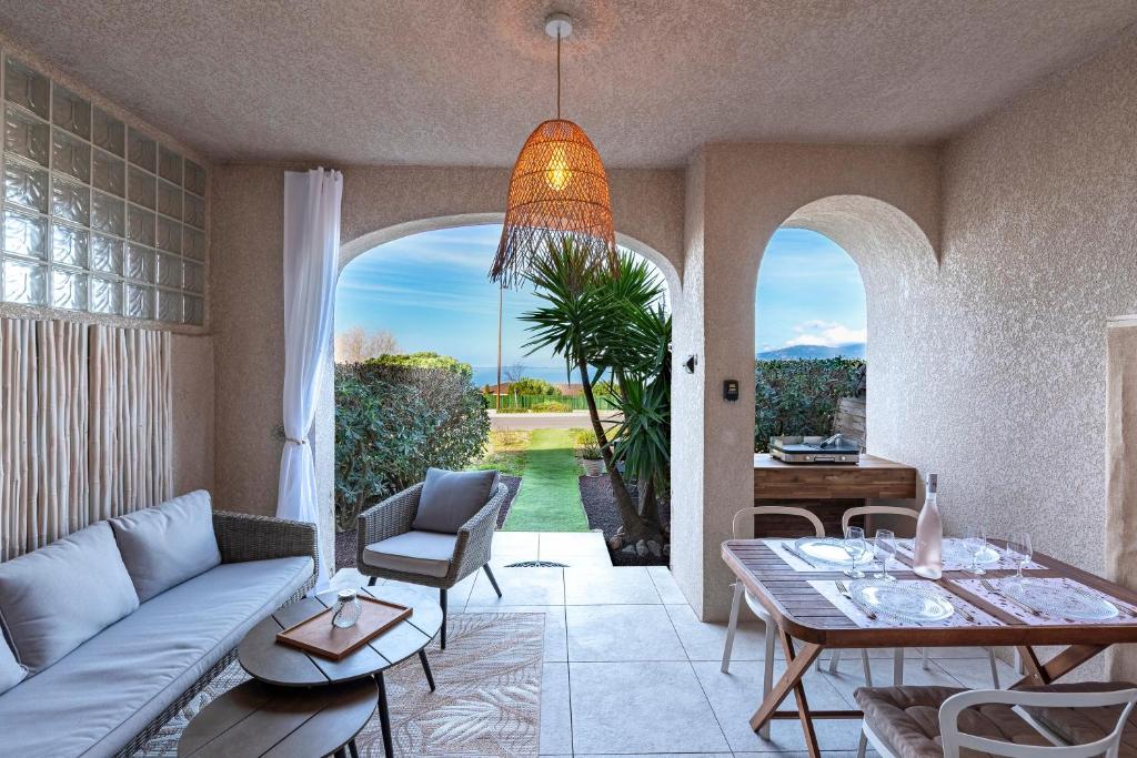 un salon avec un canapé et une table dans l'établissement Le Yucca - Vue mer 100 m de la plage, à Pietrosella
