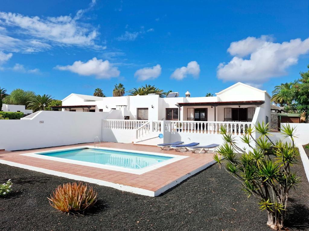 une villa avec piscine et une maison dans l'établissement Villas with private pools - Just 7 min walk from beach, bars & dining, à Playa Blanca