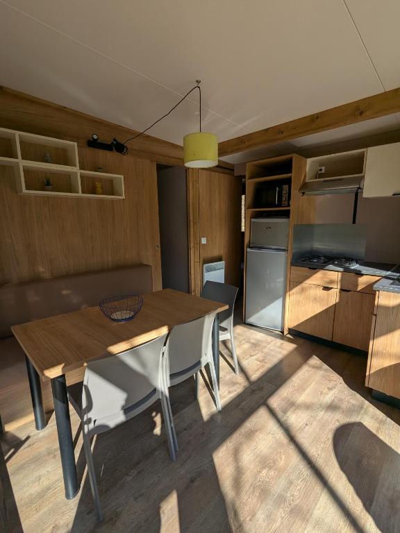 a kitchen with a table and chairs in a room at Camping Les Berges Du Doux in Colombier-le-Vieux