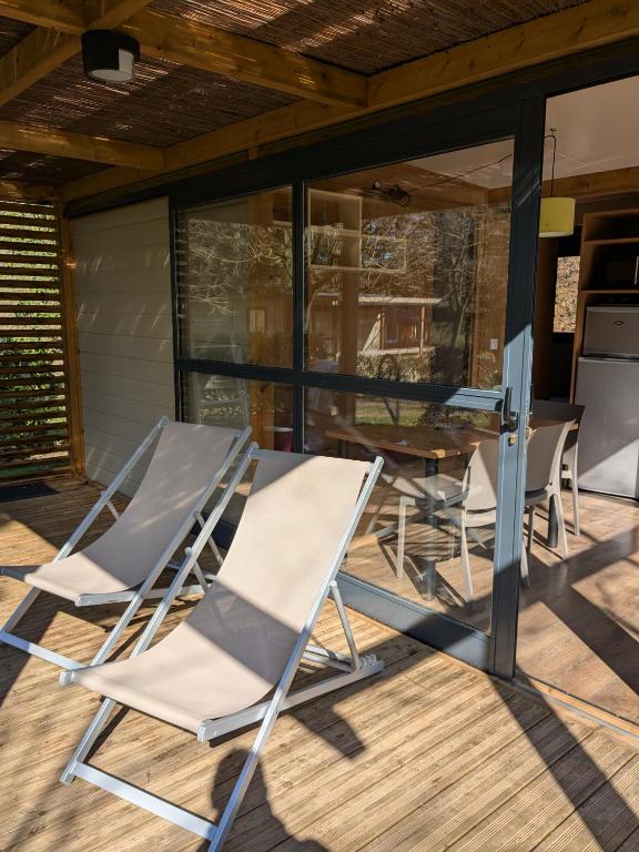 a group of chairs and a table on a patio at Camping Les Berges Du Doux in Colombier-le-Vieux
