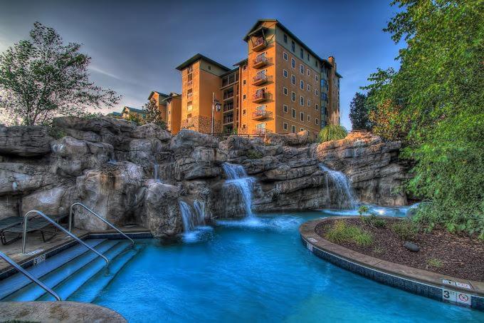 a waterfall in front of a resort with a building at Pigeon Forge Adventure #163 in Pigeon Forge