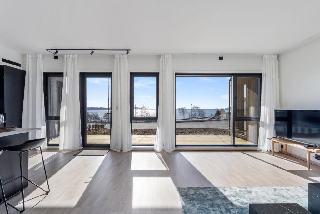 sala de estar con ventanas grandes y TV de pantalla plana en Norse Horizon, en Tau