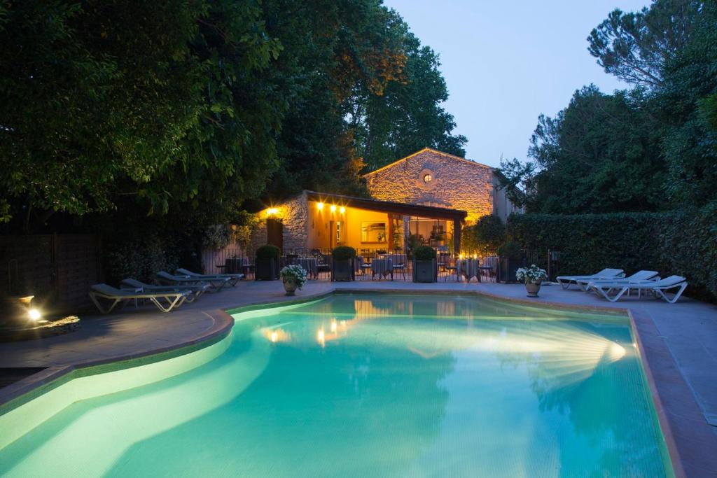 a swimming pool in front of a house at Hôtel Le Pré Galoffre in Nîmes