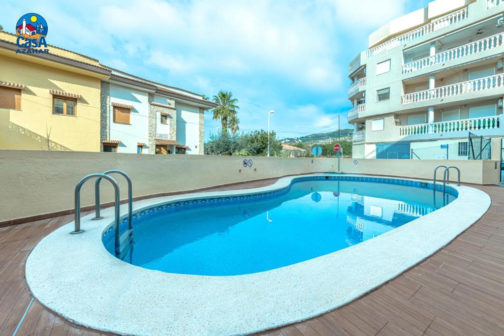 a swimming pool in front of a building at Apartamentos Los Olivos Casa Azahar in Alcossebre