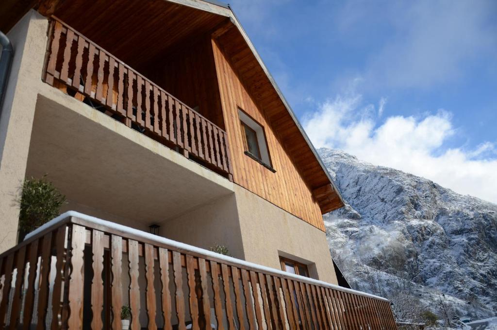 a building with a balcony in front of a mountain at Chalet Morville in Vénosc