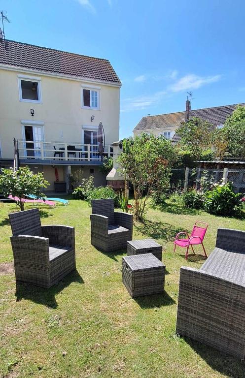 un groupe de chaises et de tables dans une cour dans l'établissement Villa Berckarosse, à Berck-sur-Mer