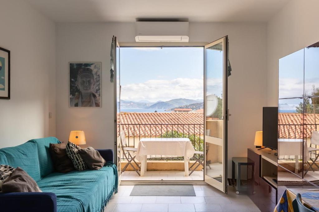 Il comprend un salon avec un canapé vert et un balcon. dans l'établissement I Certali, à LʼÎle-Rousse