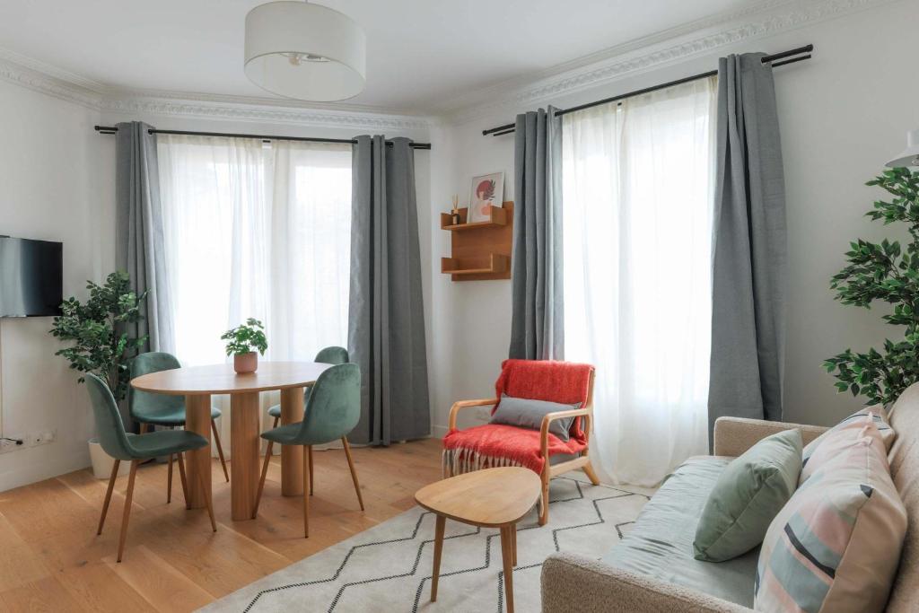 un salon avec un canapé, une table et des chaises dans l'établissement Proche Nation - Appartement à Paris 20e - Haystia, à Paris