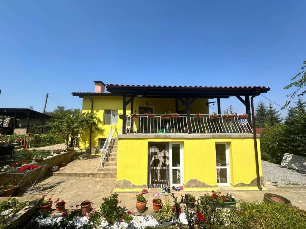 Una casa amarilla con balcón en la parte superior. en Вила Хейла, en Voditsa