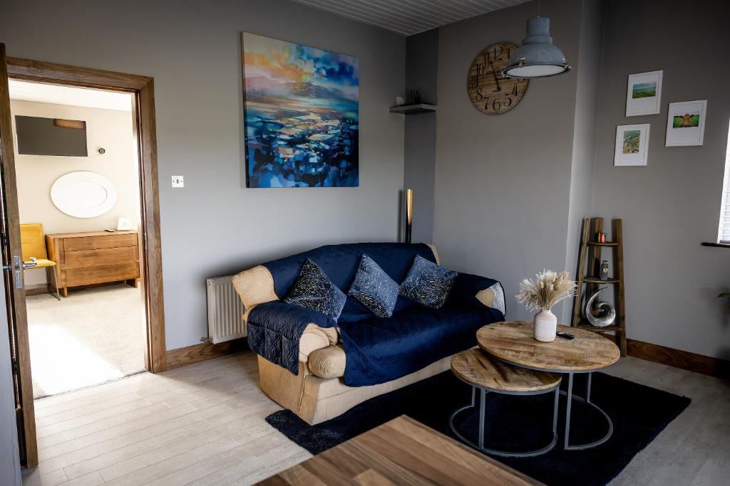 a living room with a blue couch and a table at Noel's Place in Doolin