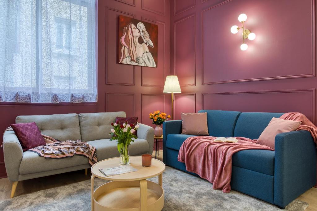 a living room with purple walls and blue couches at Chronos by Kleidos, Grand duplex, 4 personnes, 3 minutes Gros Horloge & Opéra de Rouen in Rouen