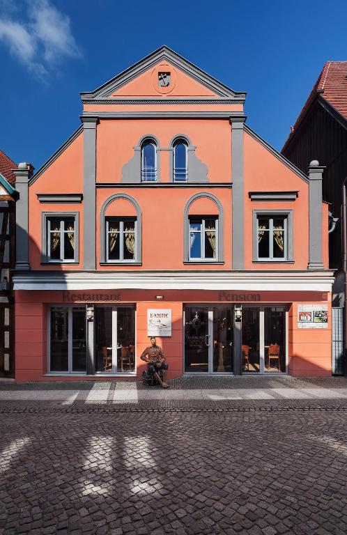 a man sitting in front of a building at U-Nautic Restaurant &amp; Pension in Waren