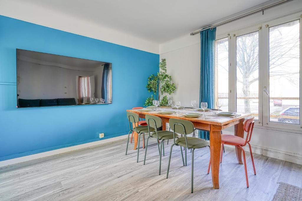 une salle à manger avec une table et des chaises en bois dans l'établissement La Villa Juliette - Charmant Appartement à 30 minutes de Paris, à Créteil