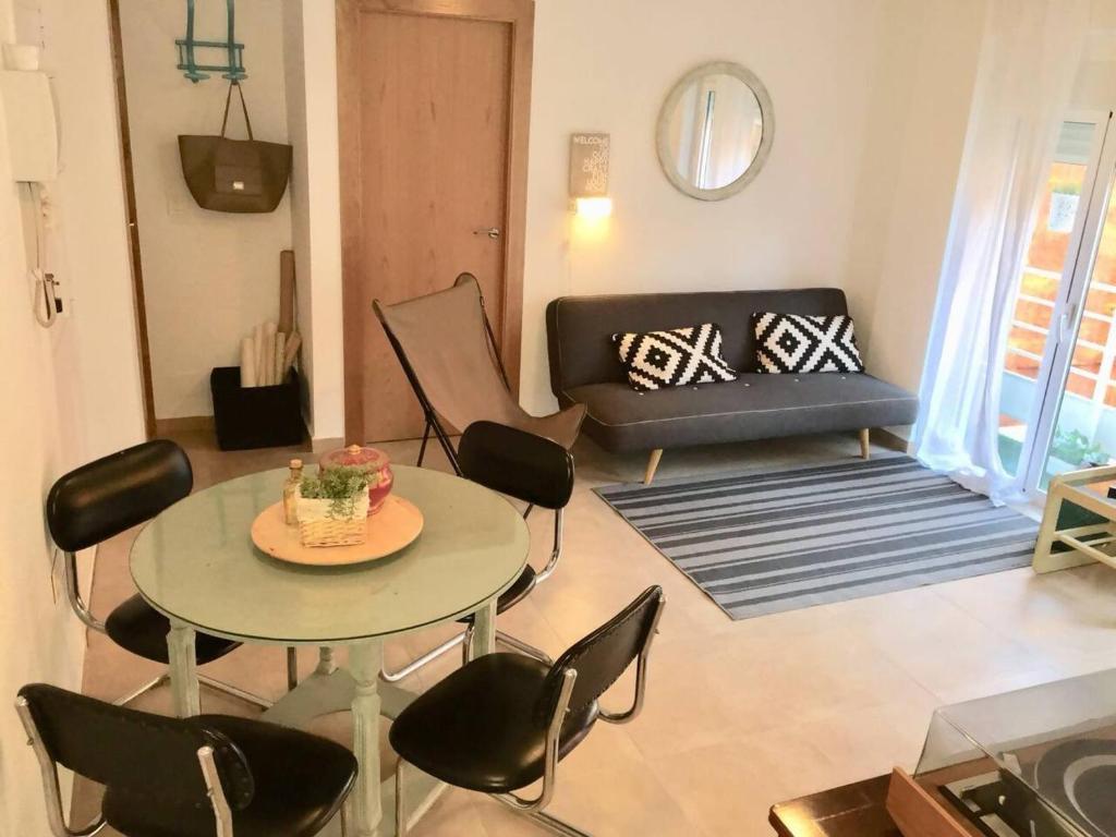 un soggiorno con tavolo, sedie e divano di Apartamento centro a Murcia