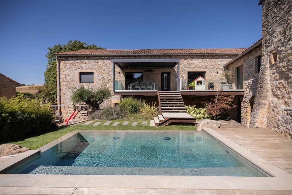 une piscine devant une maison dans l'établissement Le mas de Egines, à Saint-Rome-de-Cernon