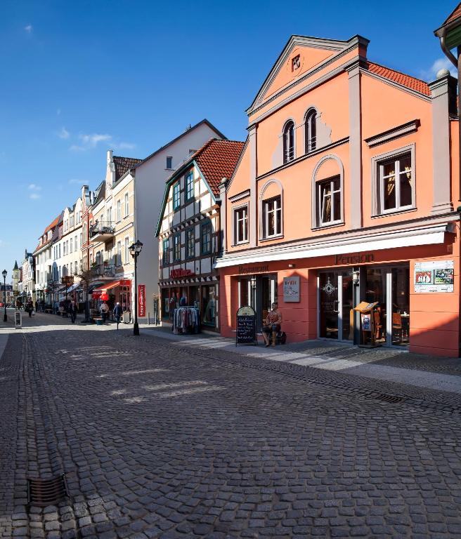 a cobblestone street in a town with buildings at U-Nautic Restaurant &amp; Pension in Waren