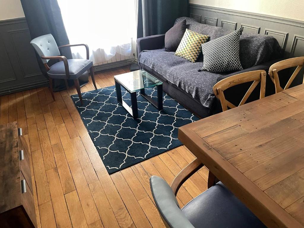 un salon avec un canapé, une table et des chaises dans l'établissement Charmant appartement Marais, à Paris