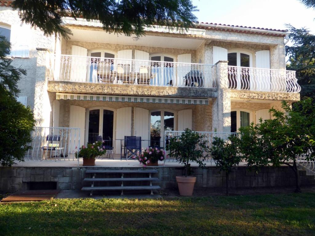 une maison avec un balcon, des tables et des chaises dans l'établissement L'Abri Côtier, à La Ciotat