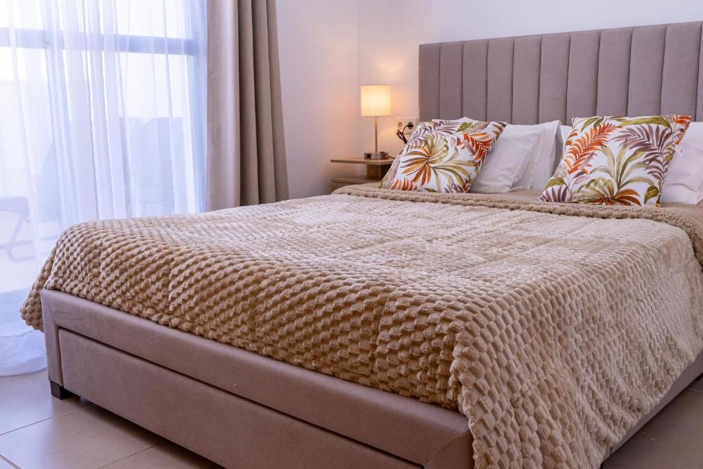 a bedroom with a large bed with a large window at Balcon Mirador De Las Salinas in Sanlúcar de Barrameda