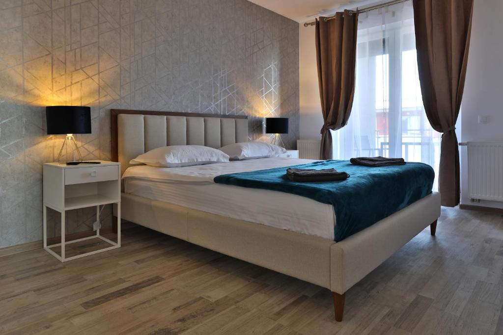 una camera da letto con un letto grande con una coperta blu di Ada Homes B4628 a Braşov