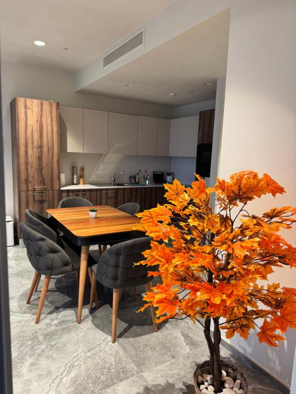a kitchen with a table and chairs and a tree at Sea view Mercury Tower, Rooftop infinity Pool in St. Julianʼs