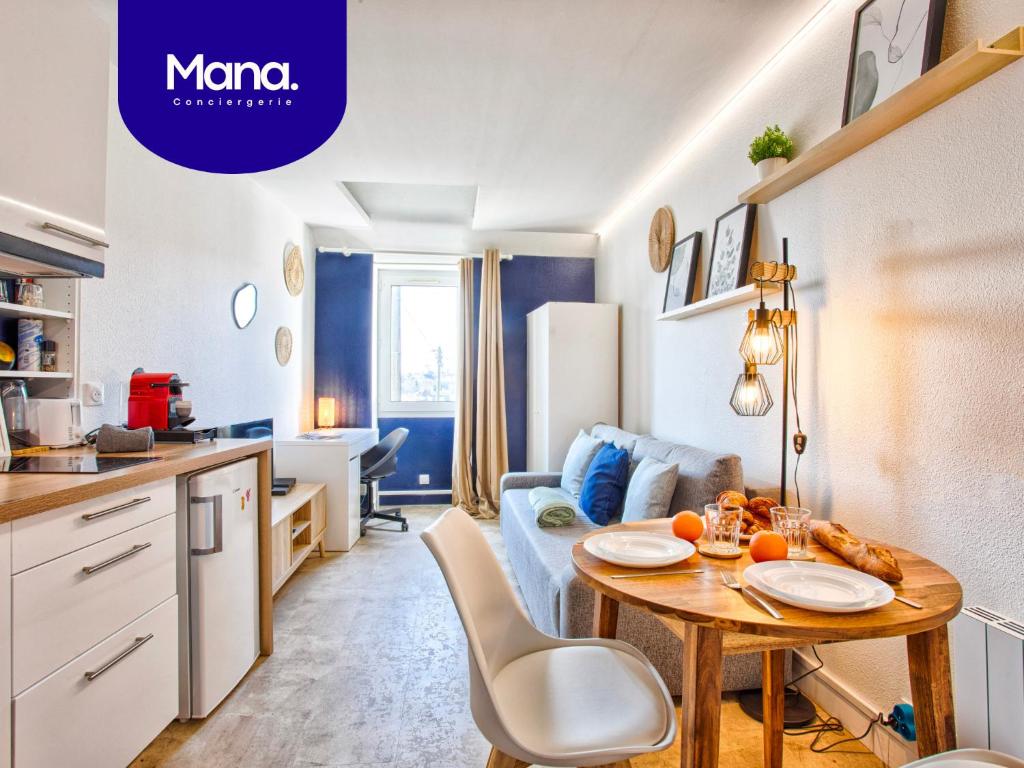 a kitchen and a living room with a table in a room at Le Tilleul - Centre ville - Parking privé - Wifi in Caen