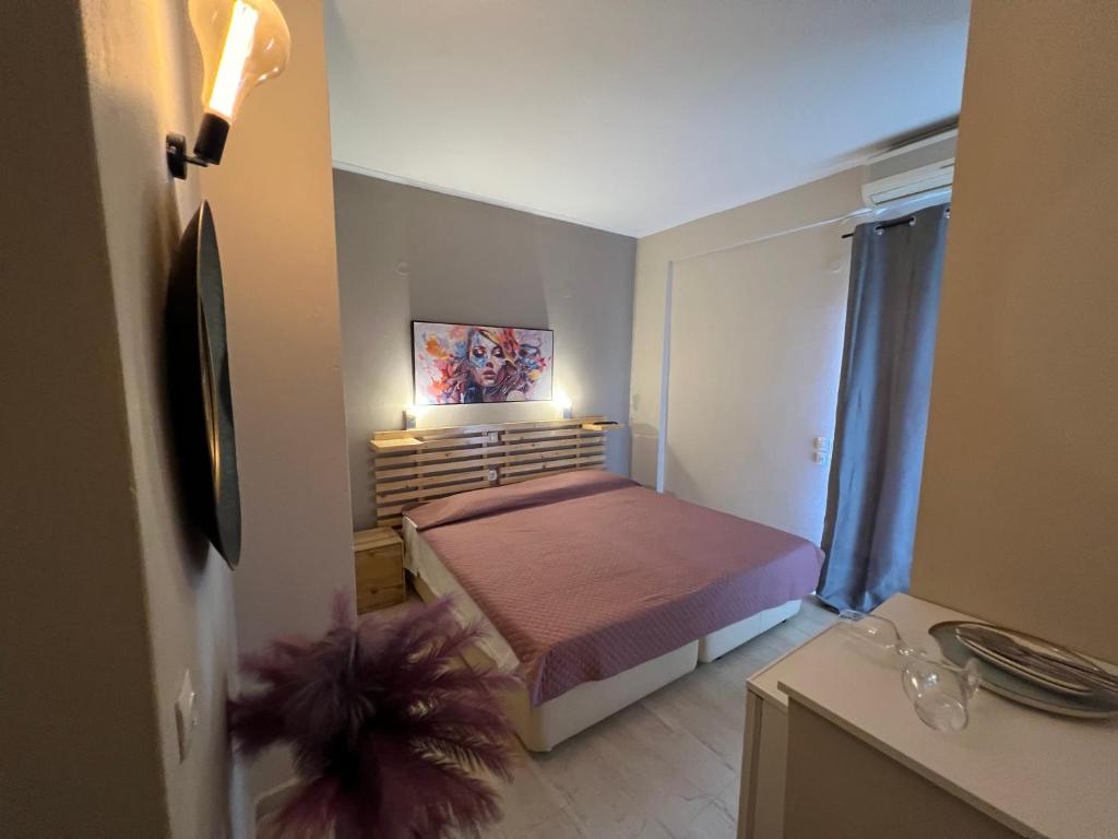 a small bedroom with a bed with two lights on it at cozy studio apartments in Moraitika
