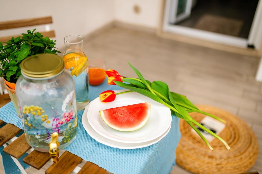 a table with a plate of watermelon and a vase at Opuntia Home in Monopoli