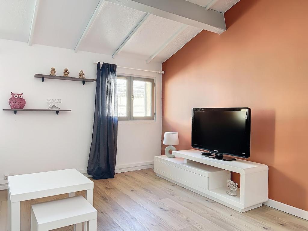 un salon avec une télévision à écran plat sur un meuble blanc dans l'établissement Charmant cocon , proche marché, port et gare, à Toulon