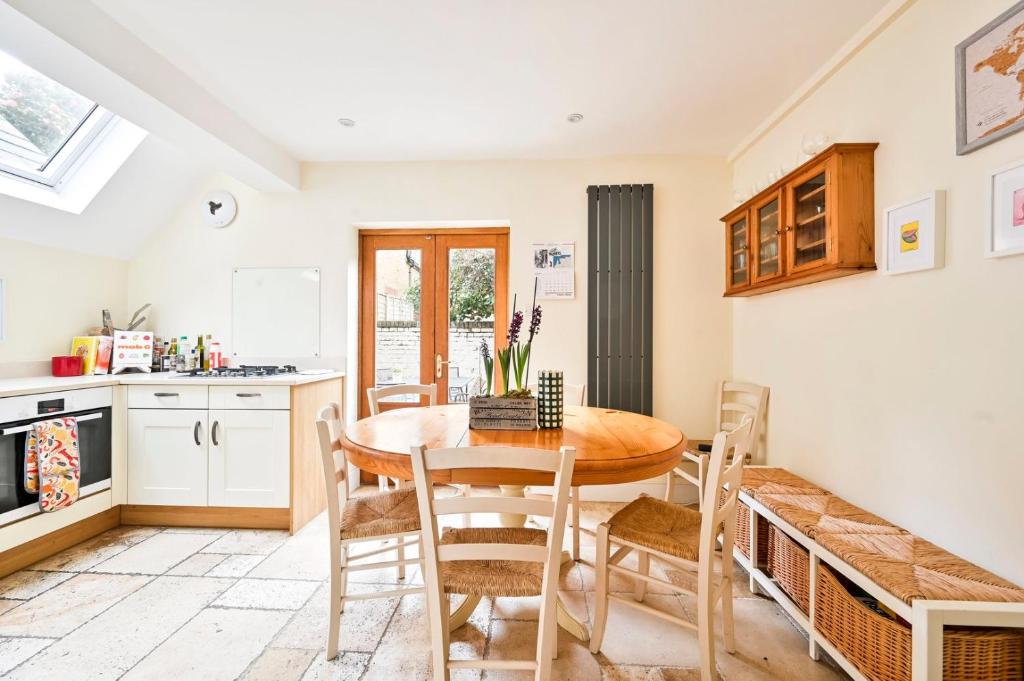a kitchen and dining room with a wooden table and chairs at GuestReady - Charming family retreat in London in London