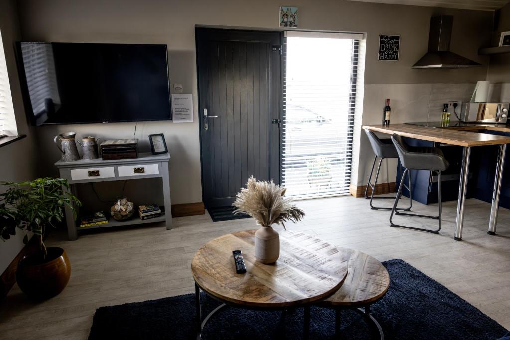 a living room with a table and a tv at Noel's Place in Doolin