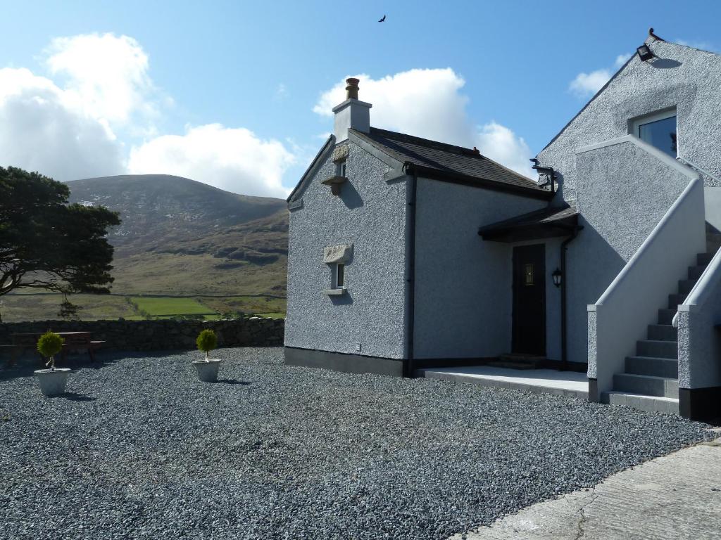 a small house with mountains in the background at Gorse Hill Farm in Newcastle