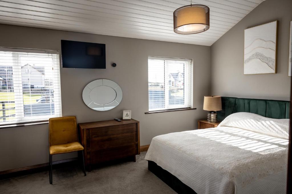 a bedroom with a bed and a mirror and a chair at Noel's Place in Doolin