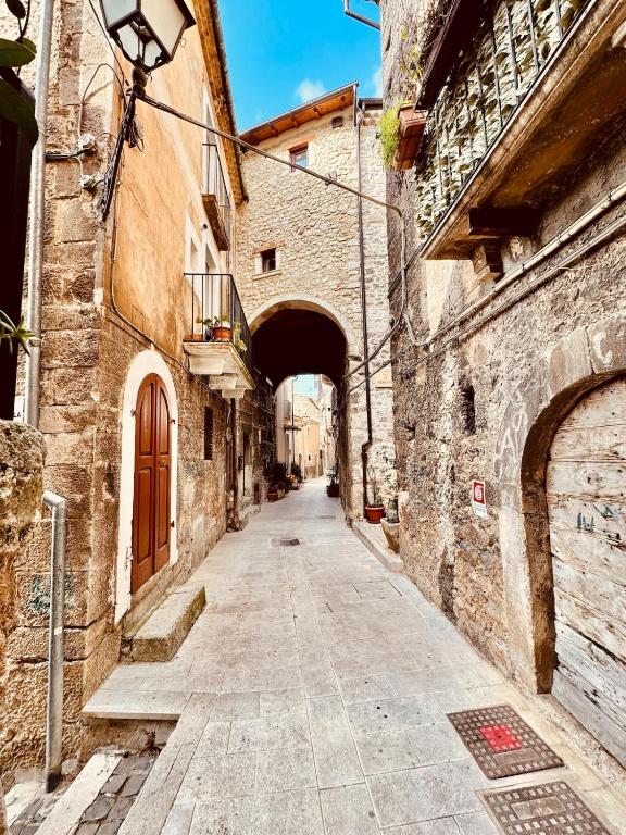 an alley with an archway between two stone buildings at La Casa sull'Arco in Pacentro