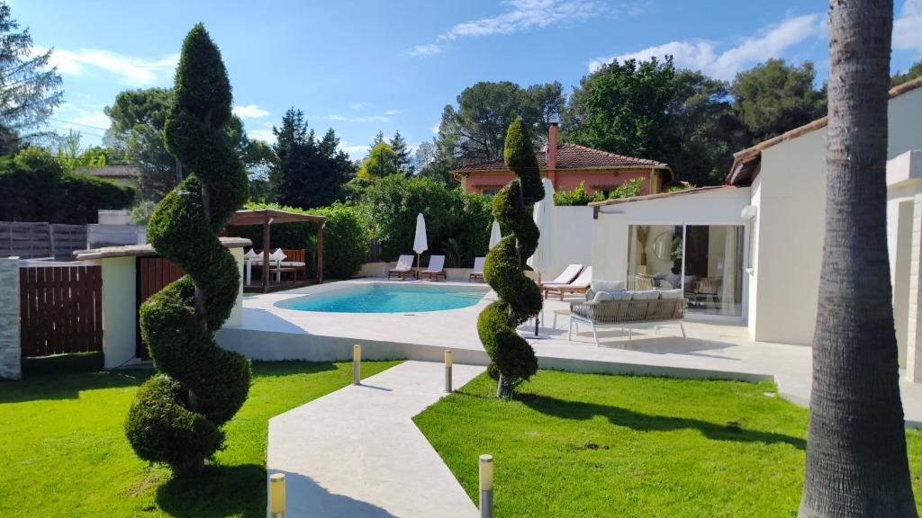 un jardin avec une piscine et une maison dans l'établissement Villa FG, à Mougins