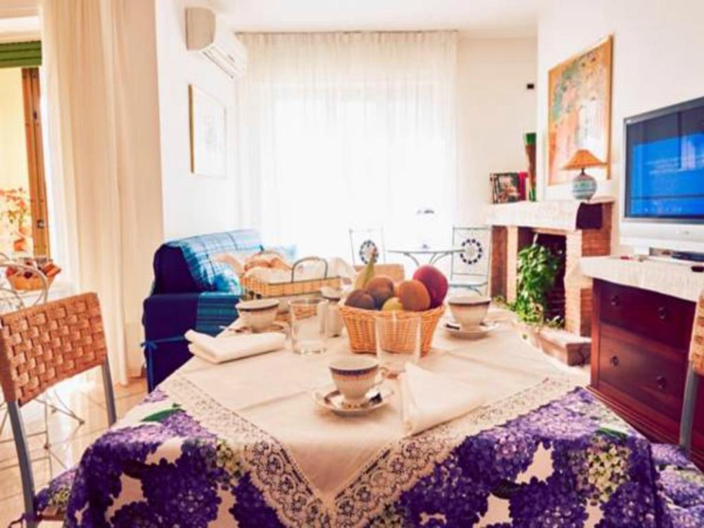 uma sala de estar com uma mesa e uma cesta de frutas em B&B Giu&Gio em Alghero