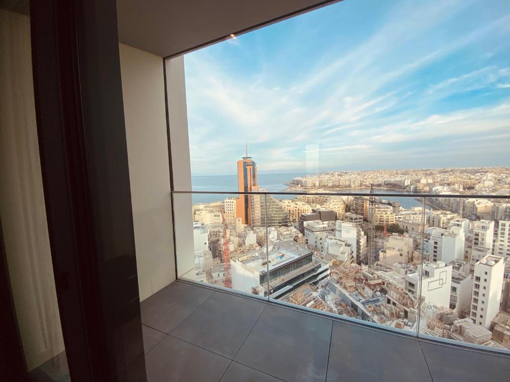 a view of a city from a high rise building at Sea view Mercury Tower, Rooftop infinity Pool in St. Julianʼs
