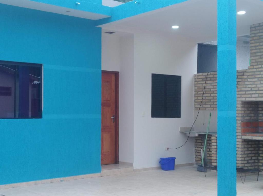 a room with white walls and a wooden door at cabaña san miguel in Ayolas
