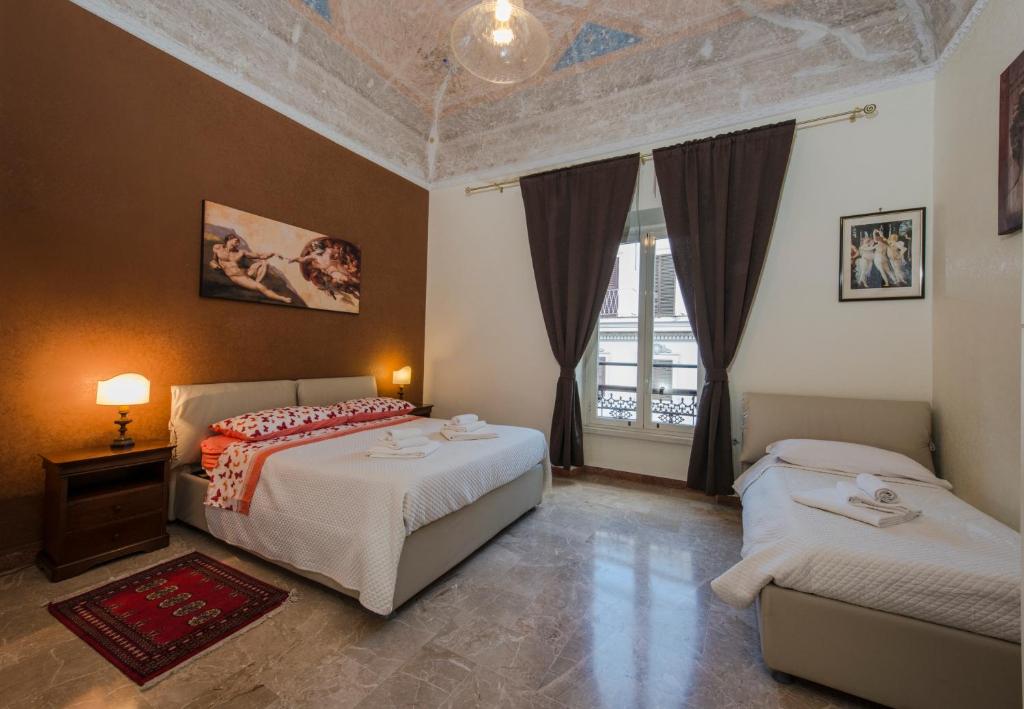 a bedroom with two beds and a window at House Montebello in Rome