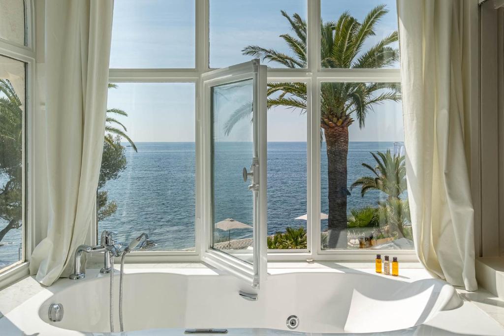 a bathroom with a tub and a large window at La Villa Mauresque in Saint-Raphaël