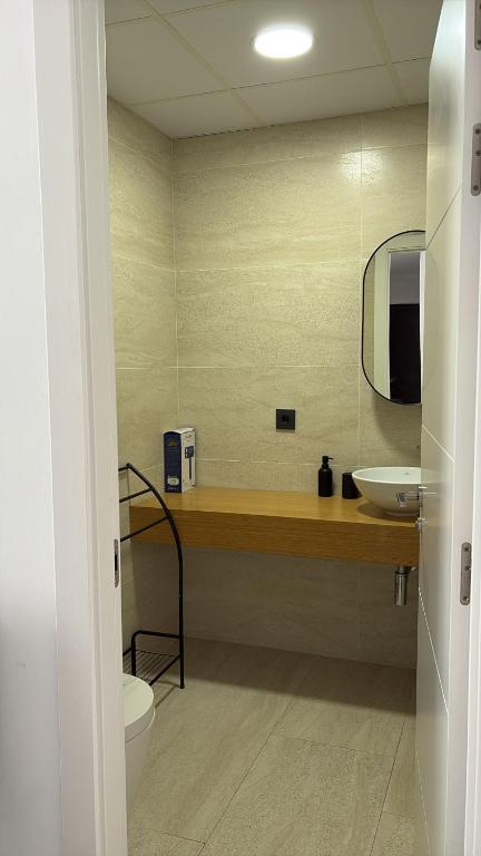 a bathroom with a sink and a toilet and a mirror at LHOME CÁDIZ in Cádiz
