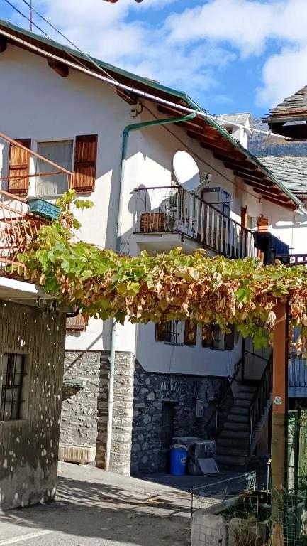 a white house with stairs and a balcony at La Sosta1-2 in Arliod